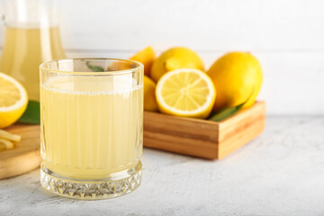 Glass with fresh lemon juice on table