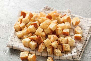 Napkin with tasty croutons on light background, closeup