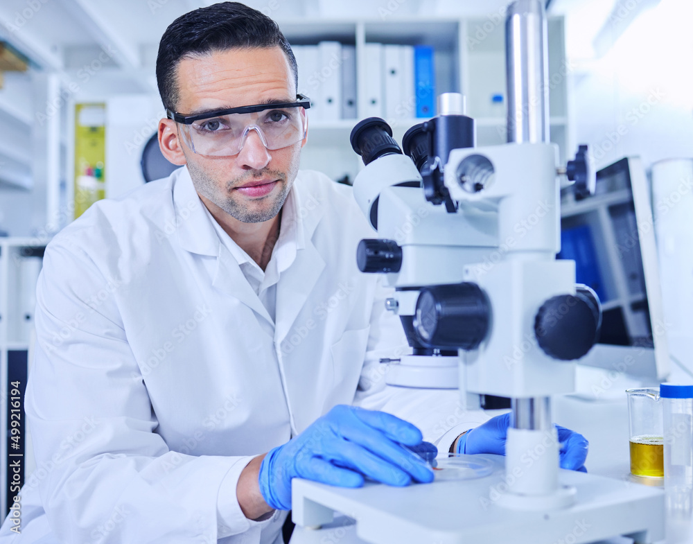 Poster sometimes you need to take a closer look. cropped portrait of a handsome young male scientist workin