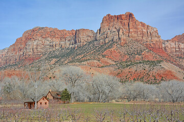 Old wooden house in desert with mountain peaks in the background in Utah near Zion National Park. 