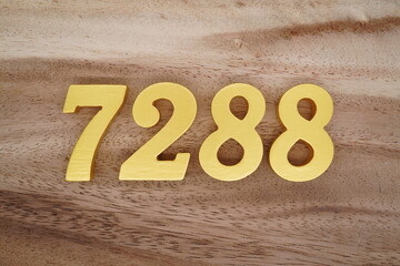 Golden Arabic numerals on a real brown and white wooden floor number 7288