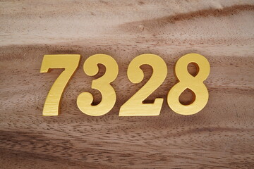 Golden Arabic numerals on a real brown and white wooden floor number 7328