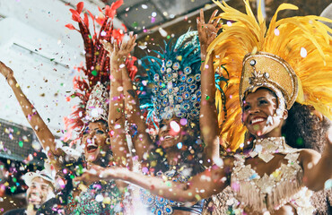 Lass uns all unsere Probleme wegtanzen. Schnappschuss von wunderschönen Samba-Tänzerinnen, die mit ihrer Band bei einem Karneval auftreten.