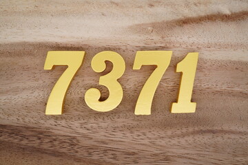 Golden Arabic numerals on a real brown and white wooden floor number 7371