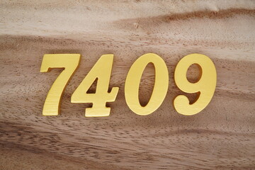 Golden Arabic numerals on a real brown and white wooden floor number 7409