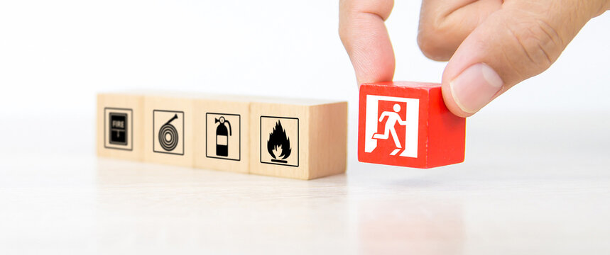 Fire prevention, Hand choose cube wooden block stack door exit sing or fire escape with prevent icon and fire extinguisher and emergency protection symbol for safety and rescue in the building.