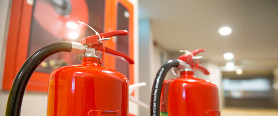 Fire extinguisher, Close-up red fire extinguishers tank in the building concepts of fire equipment for protection and prevent for emergency and safety rescue and alarm system training. - obrazy, fototapety, plakaty