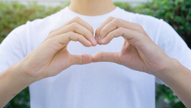 close up man hand make heart shape gesture for world kindness day or valentine day or healthy lifestyle concept