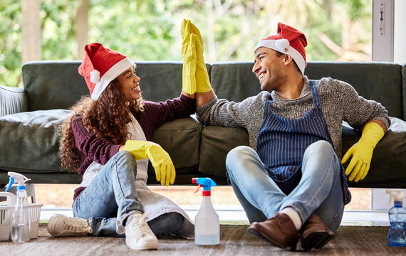 That Was A Good Cleaning Day. Shot Of A Young Couple Giving Each Other A High Five After Cleaning At Home.