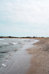 Side view of the coastline on a beach on a cloudy day
