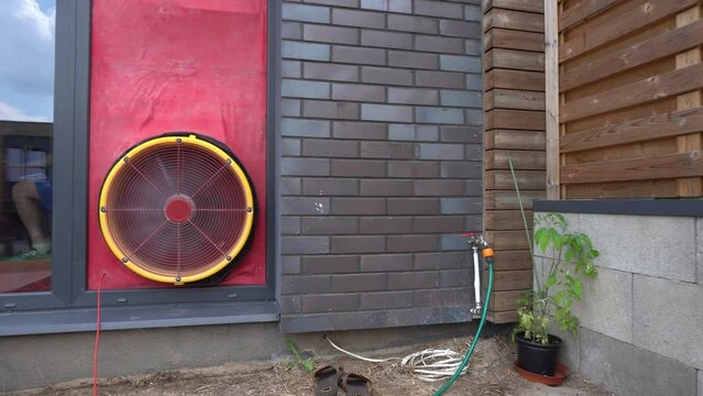 Energy efficient house testing for air tightness. Certificate passive house. Iso standards Blower door test. Gimbal movement shot.