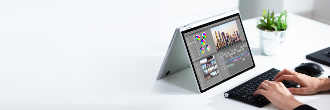 Cropped image of businesswoman using laptop at desk