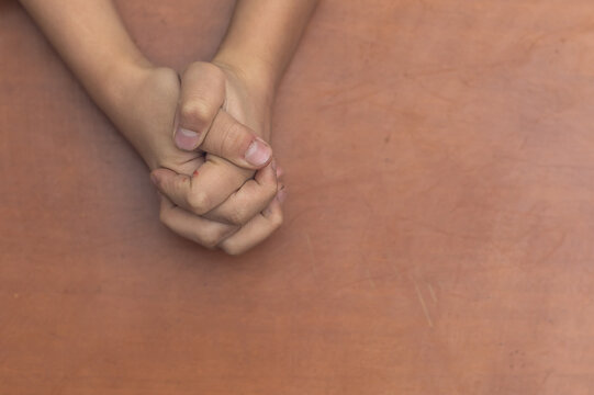 Child's hands folded together in prayer