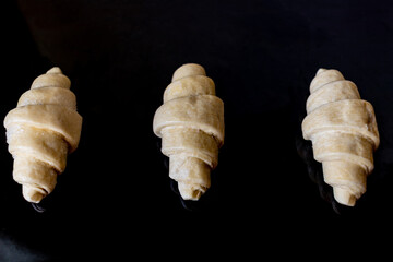 オーブン皿の上の冷凍のクロワッサンパン生地
