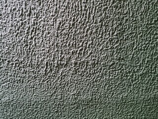 matte green paint on a rough textured wall for a text background and gradient.