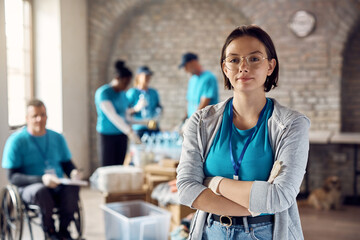 Portrait of young volunteer with her arms crossed at humanitarian aid center.