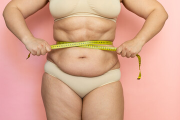 Cropped photo of naked after birth woman tummy in underwear, trying to lose weight. Holding and...