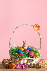 An Easter woven basket with Easter eggs stands on a linen cloth.