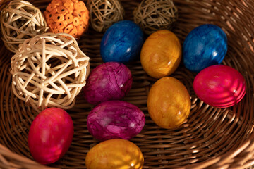 Lots of colorful chicken eggs lying in a basket. Easter.