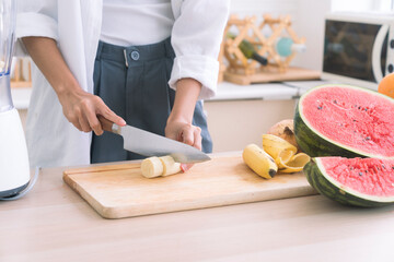 Healthy living and Vegan food. Cooking vegan food. Chef is cutting Banana to decorate a salad.
