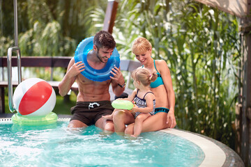 Couple with child enjoying in swimming pool