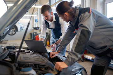 Fototapeta na wymiar Two men in auto service repairing a car