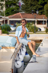 Fototapeta na wymiar man sits on a yacht and enjoys a beer at vacation