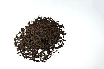 Dry black tea leaves i on white background.