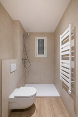 Bathroom with toilet, shower and heating radiator. Vertical view of modern minimalist interior