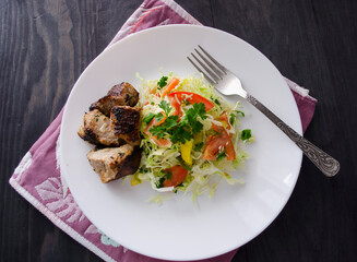 Fresh salad, barbecue, skewers on skewers with potato chips, lettuce and fresh homemade cucumbers.
