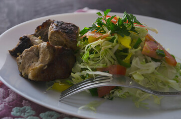 Fresh salad, barbecue, skewers on skewers with potato chips, lettuce and fresh homemade cucumbers.
