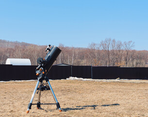 Black telescope on a tripod at the observatory for observation of stars and planets. Science,...