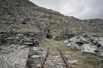 Old slate mining equipment abandoned on Lake District fells above Coniston, showing rail tracks heading into an old adit shaft