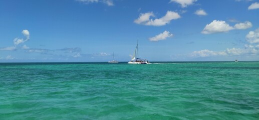 Obraz premium Boat in the ocean. Paradise in Dominican Republic. Beautiful view of the yacht in blue water.