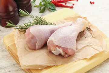 Raw chicken leg over board