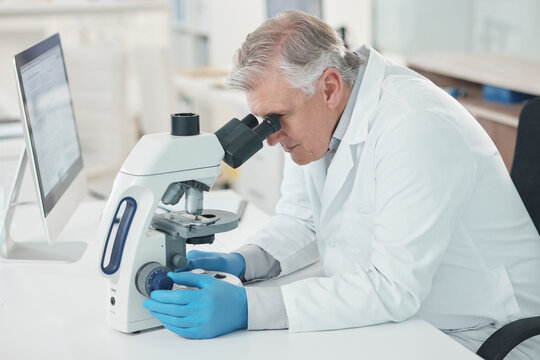 Theres a lot to take note of when magnified. Shot of a mature scientist using a microscope in a lab.