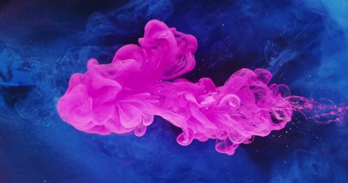Ink water drop. Color dye blend. Transition effect. Pink blue paint flow motion on dark glitter smoke texture abstract art background shot on Red Cinema camera 6k.