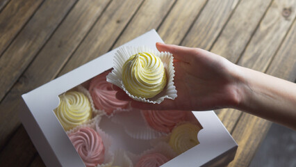 Marshmallow in package. Holiday gift concept. Hand holds sweetness.