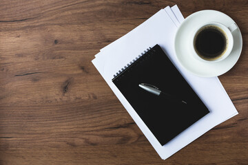 office desk with white sheets, pen and notepad.