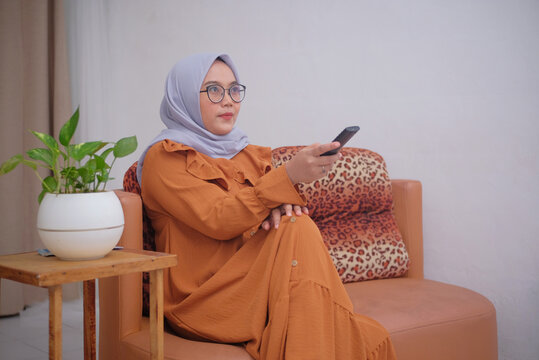 muslim woman watching tv at home