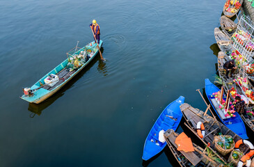 Fototapeta na wymiar A worker picks up trash on a canal in Hochiminh City, Vietnam