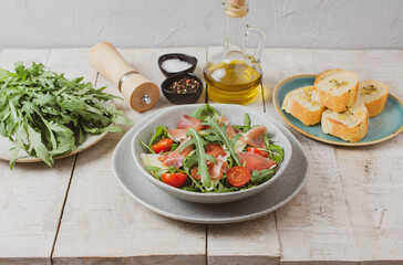 Salad with Prosciutto, olives and arugula. Cold snacks. Top view. 