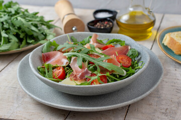 Salad with Prosciutto, olives and arugula. Cold snacks. Top view. 