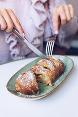 Woman eating tasty apple pie in a restaurant