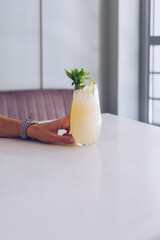 Woman is holding mai tai cocktail.