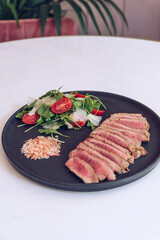 Close up of beef steak with salad on marble table.