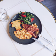 Βreakfast with omelette, bacon  and salad, top view