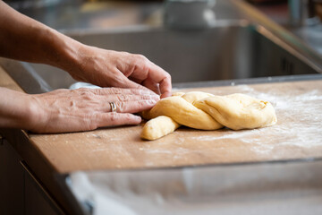 baking handmade easter braid with sweet yeast dough on countertop in kitchen