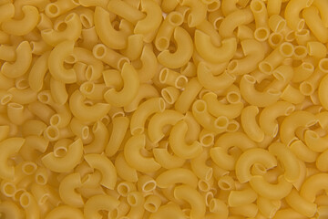 Dry raw yellow pasta. Close-up. Completely background.