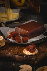 Quince cheese or marmelada is a sweet, thick jelly made of the pulp of the quince fruit. Marmalade in crackers on a kitchen counter. Dulce de membrillo in Spain